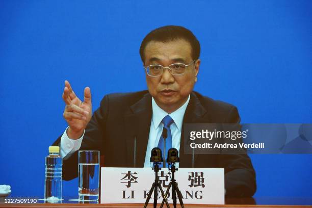 Chinese Premier Li Keqiang speaks on a large screen at a video press conference from The Great Hall Of The People after the closing of the National...
