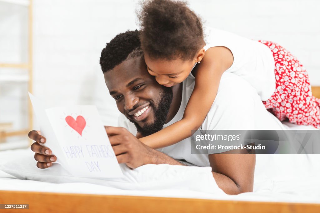 Little black girl celebrating Father's Day with daddy