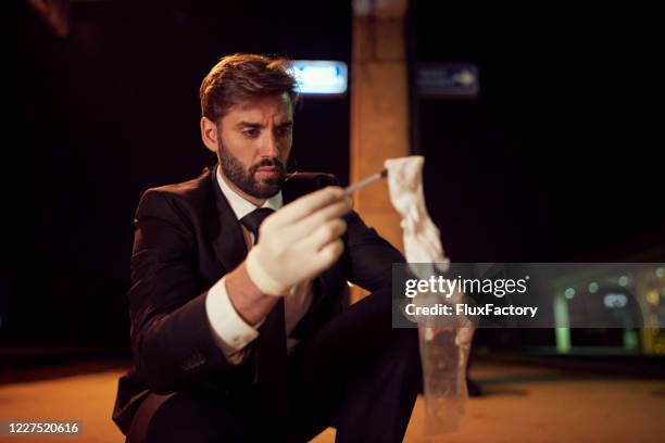 fbi inspector collecting an evidence at the crime scene - forensic science stock pictures, royalty-free photos & images