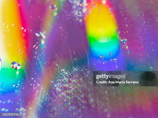 water drops and holographic reflections on the surface of a compact disc - colorful cd stock pictures, royalty-free photos & images