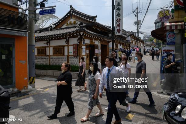 Customers queue outside the Tosokchon Samgyetang restaurant in Seoul on July 16, 2020. - South Korea marks 'Chobok', the first day of what is...