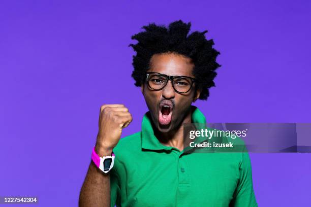 colored portrait of angry young man raising fist - color blocking stock pictures, royalty-free photos & images