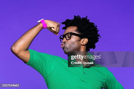 Gekleurd portret van funky jonge mens met het tonen van biceps Gekleurd portret van funky jonge mens met het tonen van biceps