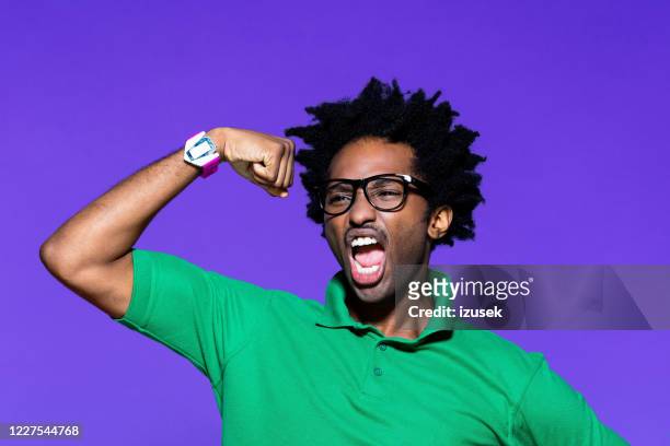 colored portrait of funky young man with showing bicep - bloco de cor imagens e fotografias de stock