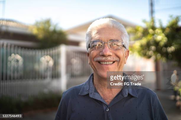 porträt eines lächelnden seniors auf der straße - mann schlicht stock-fotos und bilder