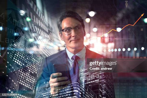 successful business man working in the global stock market using his cell phone - hedge fund stock pictures, royalty-free photos & images
