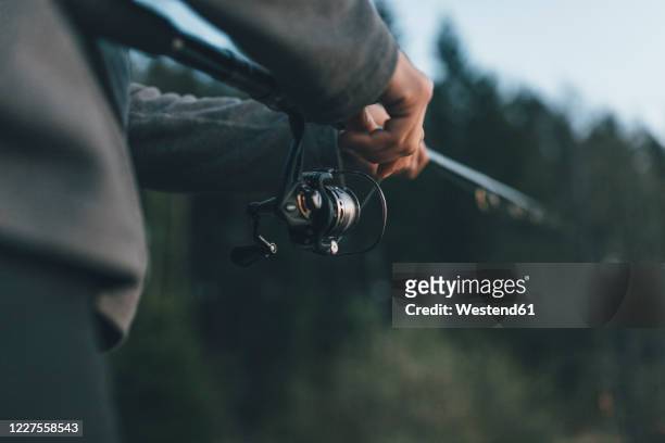 close up of man holding fishing rod - angel stock-fotos und bilder