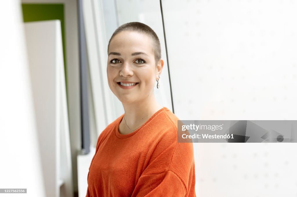 Portrait of smiling young woman at the window in office