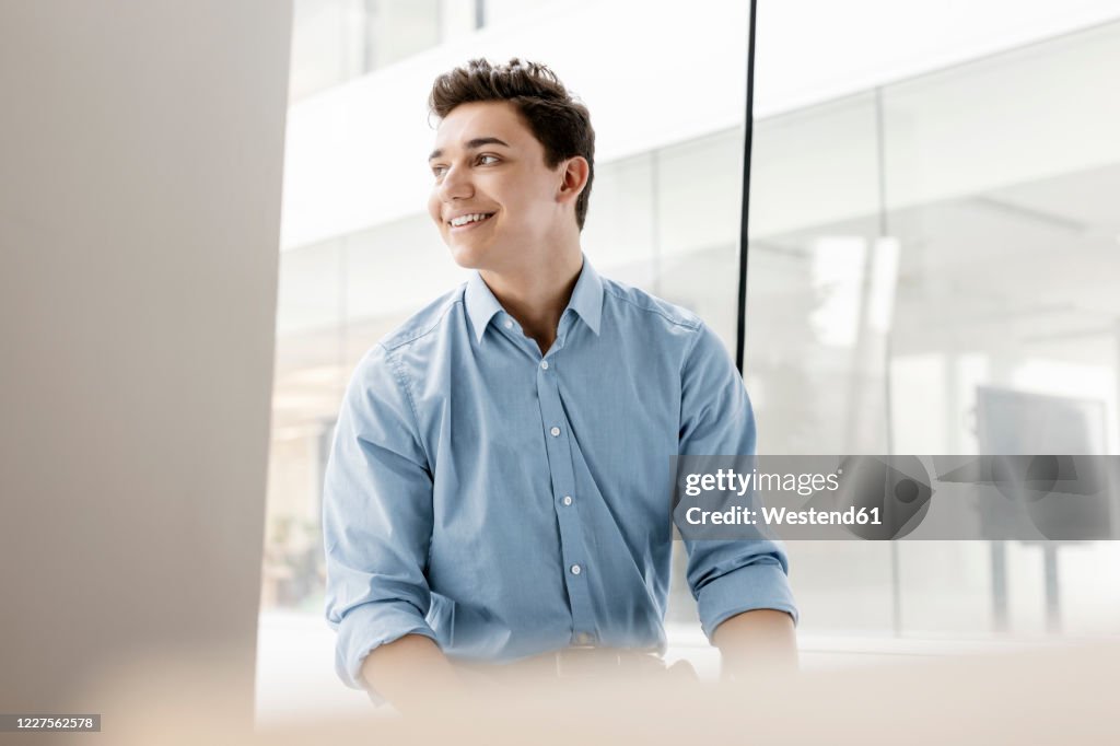Portrait of smiling young businessman at the window in office