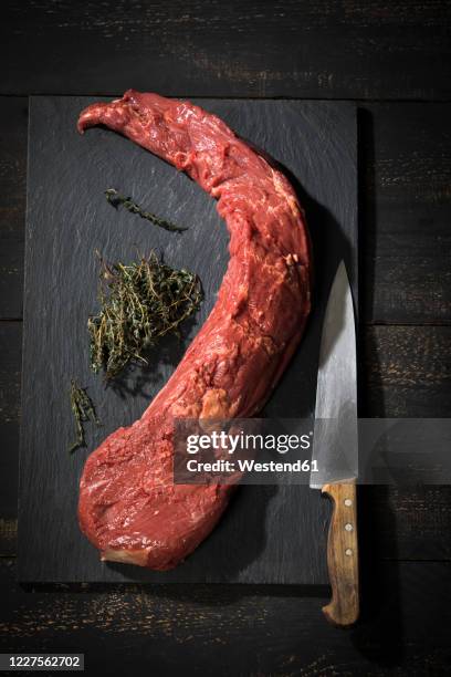 cutting board, kitchen knife, herbs and raw tenderloin - tenderloin filetsteak stock-fotos und bilder