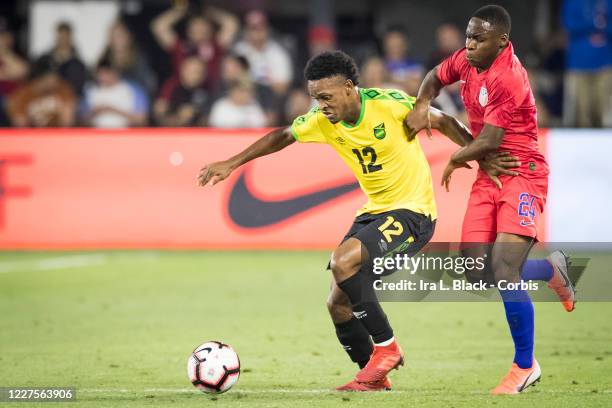 Jonathan Amon of the United States fights for the ball against Junior Flemmings of Jamaica with the Nike logo behind them during the International...