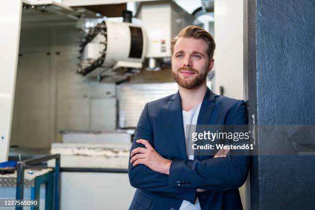 portrait of a confident young businessman in a factory - blue blazer stock pictures, royalty-free photos & images