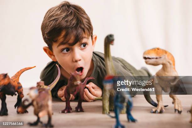 portrait of little boy playing with toy dinosaurs - toy animal stock pictures, royalty-free photos & images