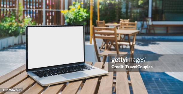 laptop computer blank white screen on table in cafe background. laptop with blank screen on table of coffee shop blur background. - 薄い ストックフォトと画像