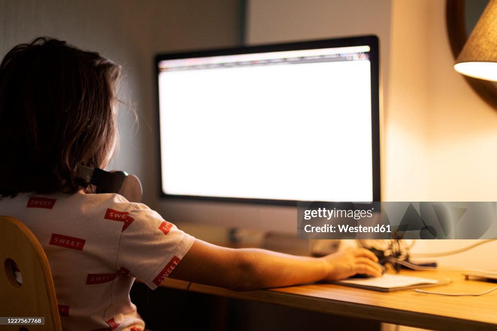 Boy Using Computer Lab Back View Rear View Of Boy Using Computer While Sitting At Illuminated Desk High ...