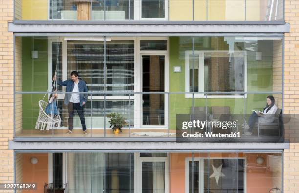 family spending time together on balcony - neighbors balcony stock pictures, royalty-free photos & images