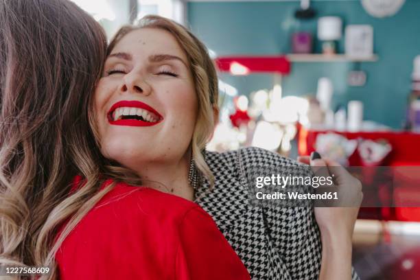 happy elegant woman meeting her girlfriend in a shop - red blazer stock pictures, royalty-free photos & images