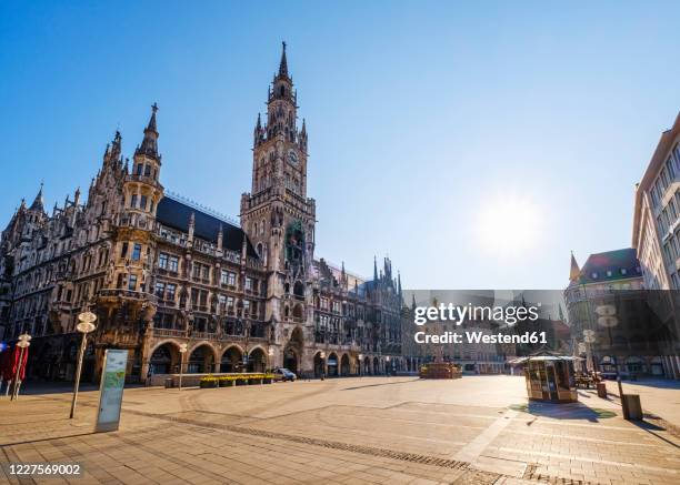 germany, bavaria, munich, sun shining over deserted marienplatz - plaza stock-fotos und bilder