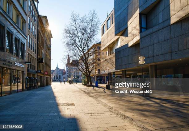 germany, bavaria, munich, sun shining over empty neuhauser strasse street - städtische straße stock-fotos und bilder