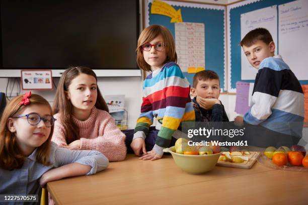 portrait of five children in a classroom during break time - fruit bowl stock pictures, royalty-free photos & images