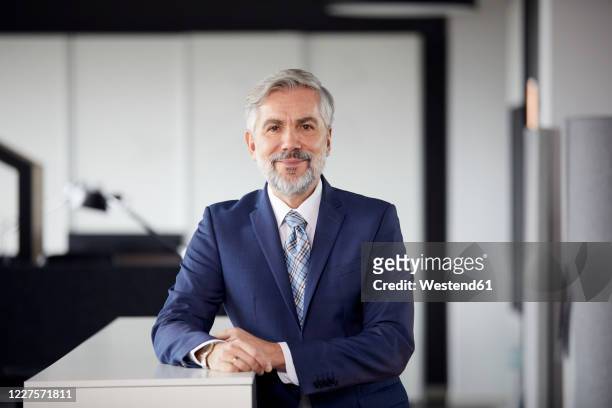 portrait of confident mature businessman in office - smiling tie stock-fotos und bilder