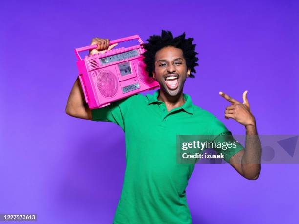 summer portrait of funky young man holding pink boombox - boom box stock pictures, royalty-free photos & images