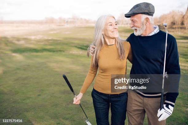 happy senior couple enjoying recreating with golf - luxury club stock pictures, royalty-free photos & images