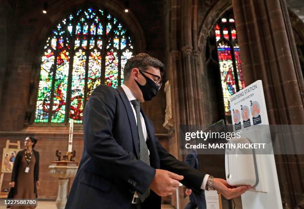 Mayor of Greater Manchester Andy Burnham sanitises his hands before a memorial service for the victims of the novel coronavirus at Manchester...