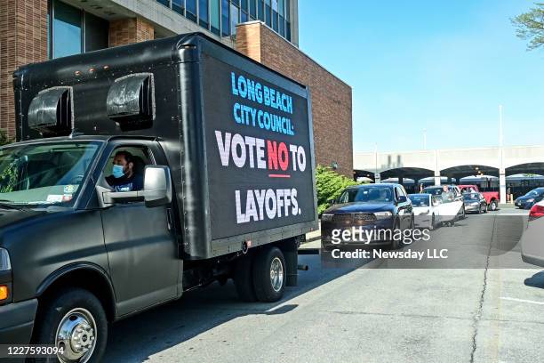 Members of the Long Beach, New York CSEA civil service union hold a drive-by protest in front of Long Beach City Hall to protest further union...