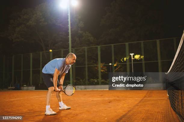 amateur tennis player on clay court - amateur tennis man stock pictures, royalty-free photos & images