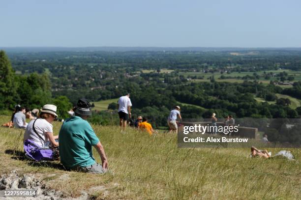 Members of the public enjoy the view as they sit on Box Hill on May 28, 2020 in Tadworth, England. The British government continues to ease the...