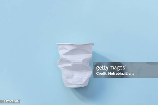 plastic utensils. social environmental problem. plastic pollution of the planet. white plastic on a blue background. environmental disaster. sorting and processing of sticks. - disposable cup foto e immagini stock
