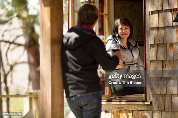 two women chatting on a porch. - schwätzchen mit dem nachbarn stock-fotos und bilder