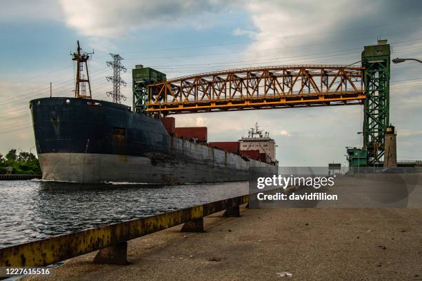 hamilton, ontario - cargo ship coming into dock through the lift bridge and lake ontario - hamilton stock pictures, royalty-free photos & images