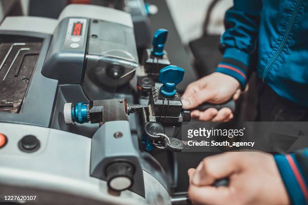 locksmith cutting car key with his machine - key stock pictures, royalty-free photos & images