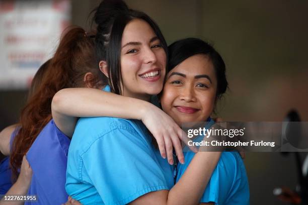 Staff embrace as they and members of the public take part in the weekly "Clap for Our Carers" event at Aintree University Hospital on May 28, 2020 in...