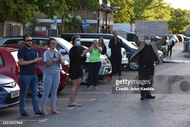 Member of the public holds up a placard saying "Thank you for caring for my wife" outside the emergency department during the clap for carers at the...