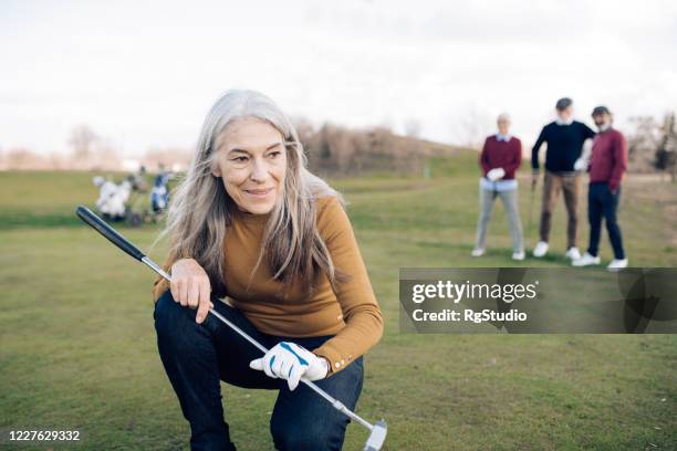 porträt einer seniorin, die einen golfschuss gemacht hat - playing golf stock-fotos und bilder