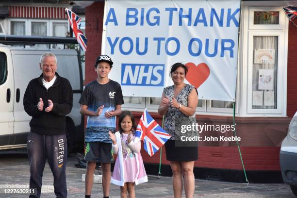 Parents with their children Daniel and Zara stand outside their home with a sign saying "A big thank you to our NHS" opposite the hospital during the...