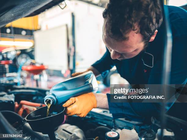 自動車に取り組む自動車整備士 - 潤滑油 ストックフォトと画像