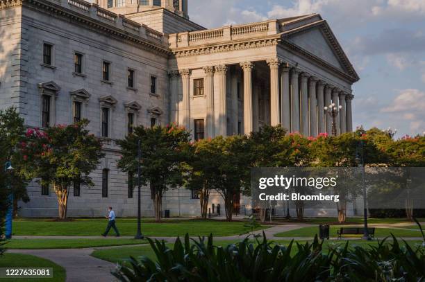 Pedestrian wearing a protective mask passes in front of the South Carolina State House in Columbia, South Carolina, U.S., on Wednesday, July 15,...