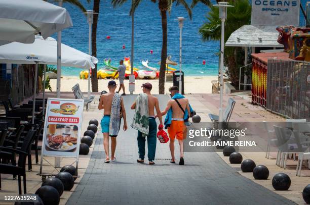 Tourists walk at General Garcia Ruiz street in Magaluf, Calvia, in Spain's Balearic island of Majorca on July 16, 2020. - Regional authorities on...