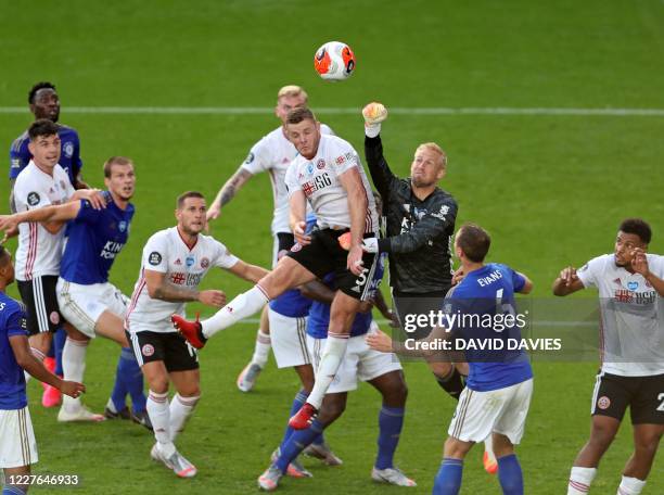 Sheffield United's English defender Jack O'Connell jumps to head the ball as Leicester City's Danish goalkeeper Kasper Schmeichel comes out to punch...