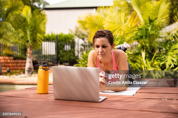 confident woman exercising and doing online fitness live streaming class by the pool - australia media training opportunity stockfoto's en -beelden