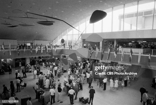 Interior view of the International Arrival Building at John F. Kennedy International Airport shows a crowd of passengers as they stand under a...