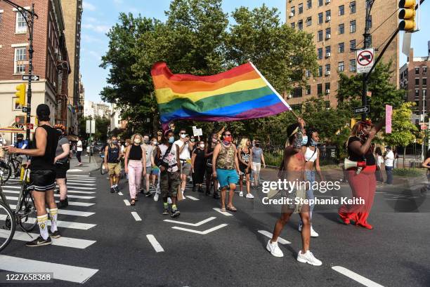 People march in the street near the Stonewall Inn on July 16, 2020 in New York City. People gather to celebrate both Black history in the Americas...