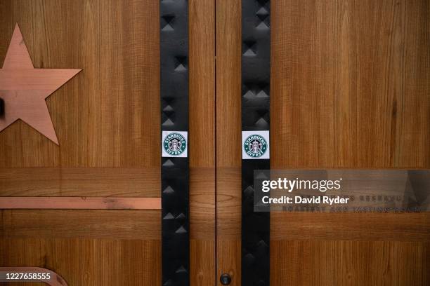 Starbucks Divest stickers are seen on the front doors of the Starbucks Reserve Roastery during a march and rally calling for the barista's divestment...