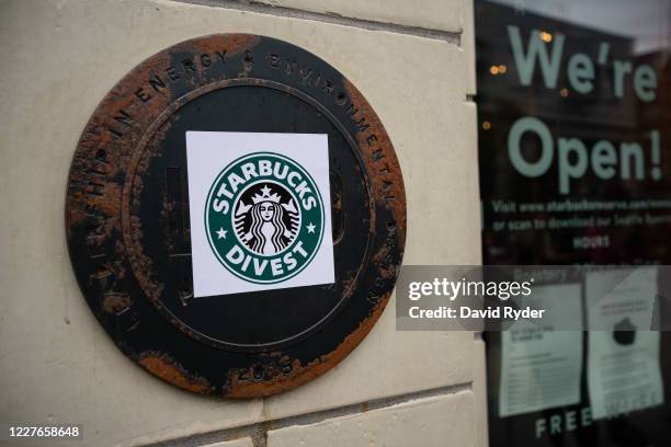 Starbucks Divest sticker is seen on a plaque outside the Starbucks Reserve Roastery during a march and rally calling for the barista's divestment...