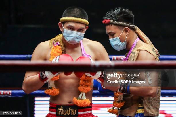 Petch Lamsin and Thongchai Petchungrueang wearing face masks are seen before the Thai Boxing match that was held without spectators as a preventive...
