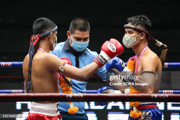Bai Phai Yotharak and Rak Sommai Ngo Bangkapi are seen in action during the Thai Boxing match that was held without spectators as a preventive...